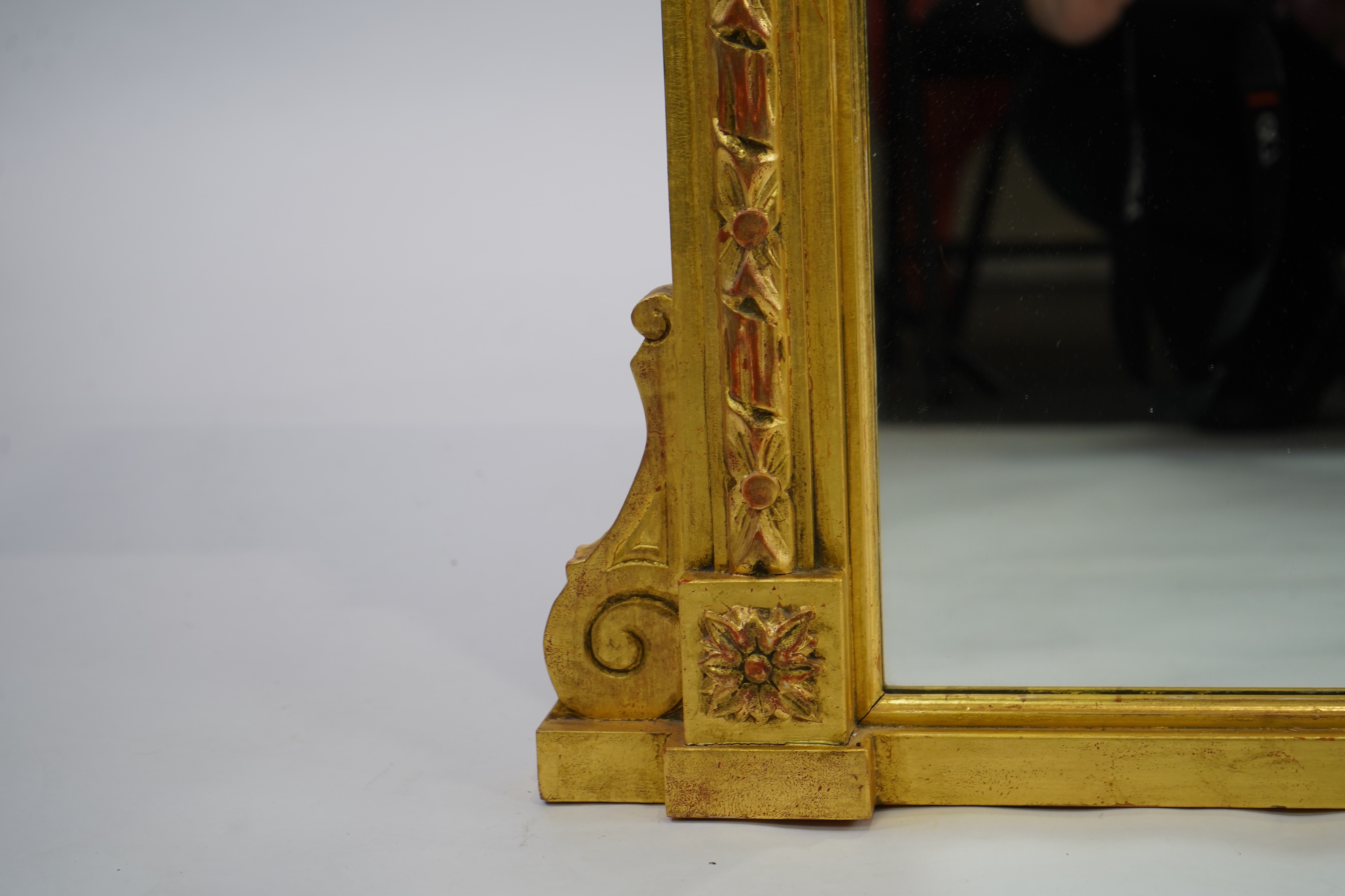 A Victorian style giltwood and composition triple plate overmantel mirror, with foliage scroll torch pediment over a flower head frieze and fluted pillars, 222cm wide,152cm high